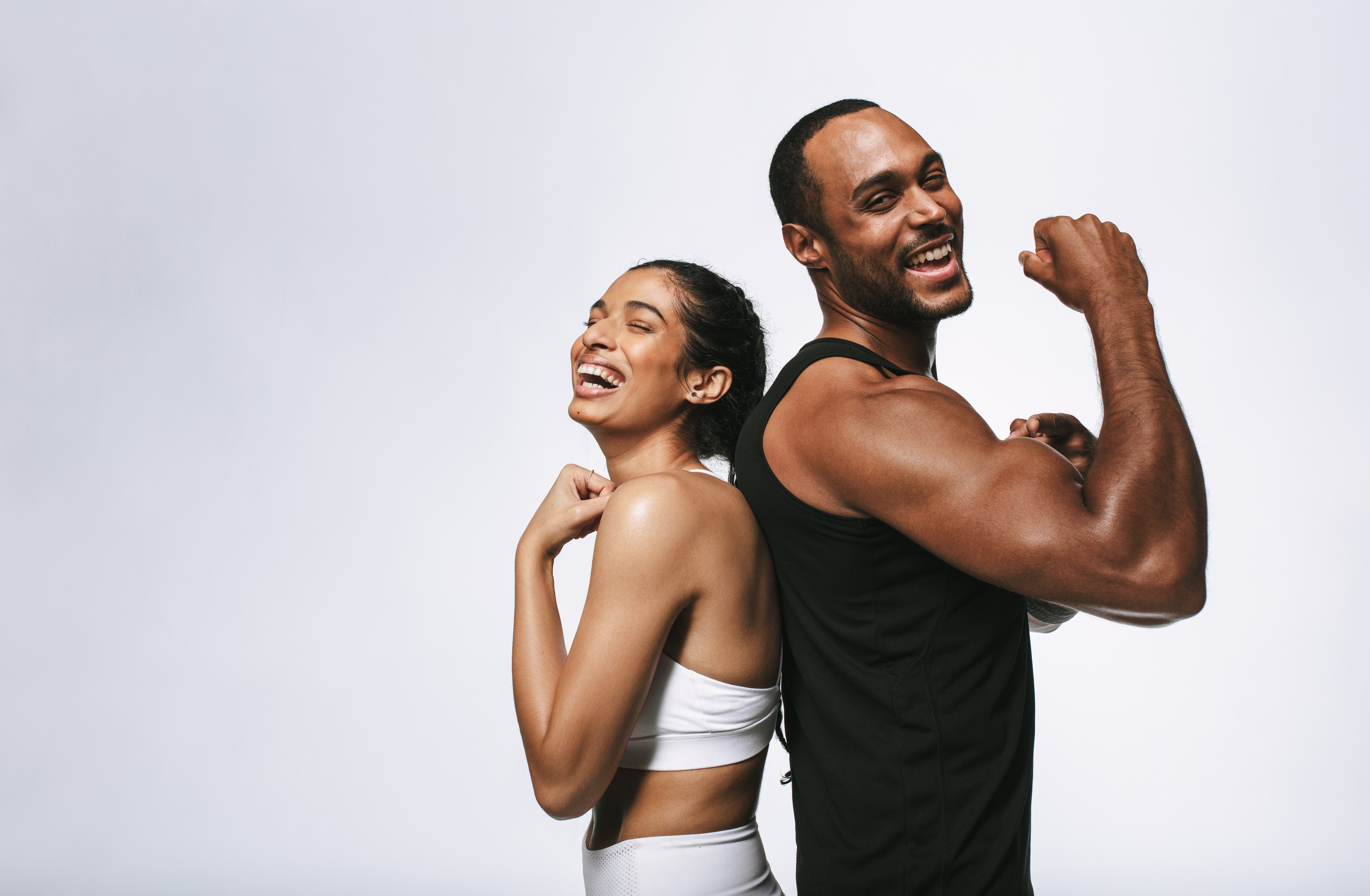 Smiling fitness couple standing back to back
