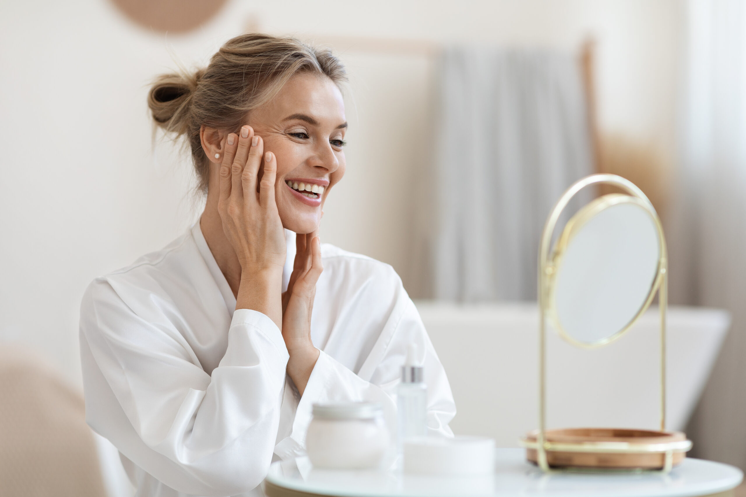 Smiling blonde woman making anti-aging face massage Smiling blonde woman making anti-aging face massage