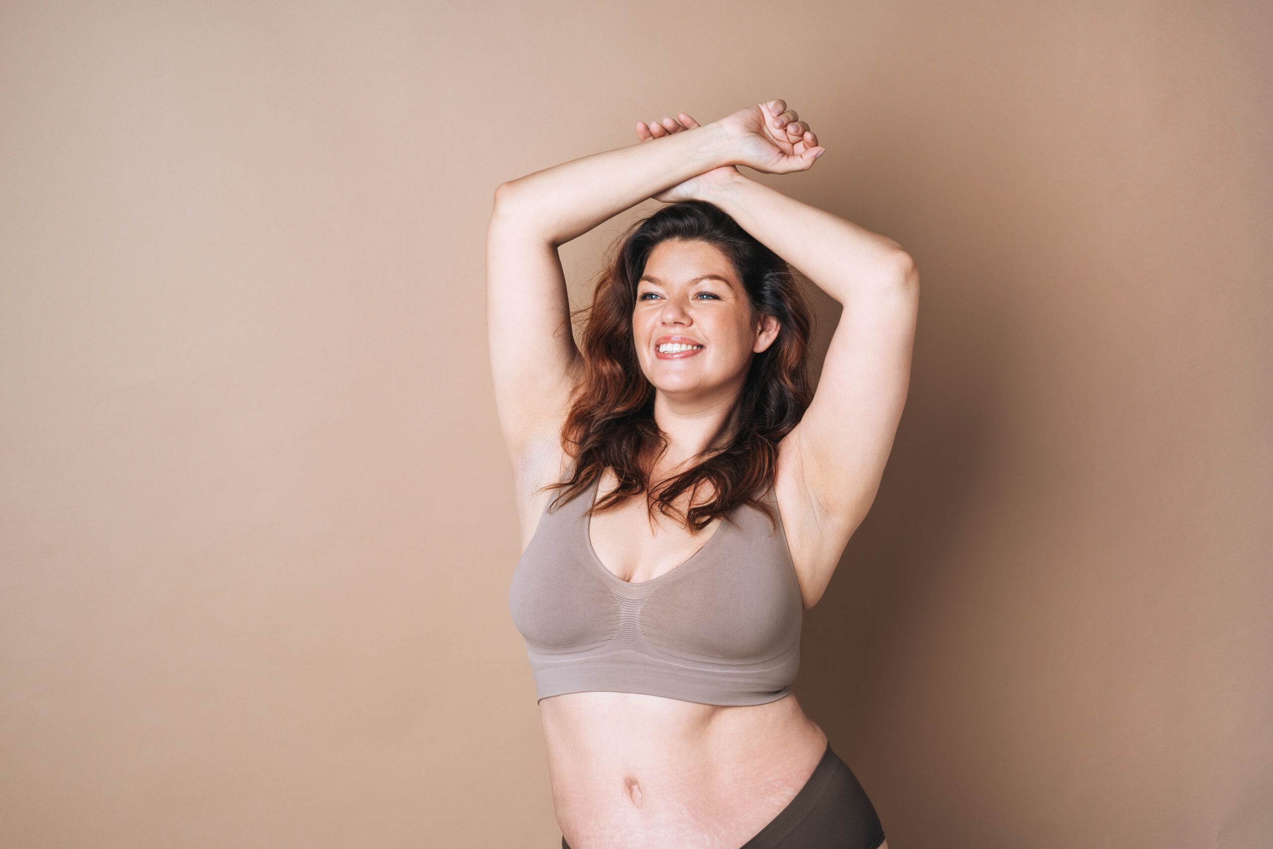 self loving woman plus size in underwear on beige background, 