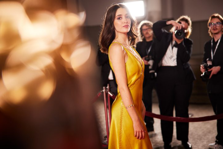 The Young Actress Poses For The Camera In Side View, Her Gaze Directed At The Lens